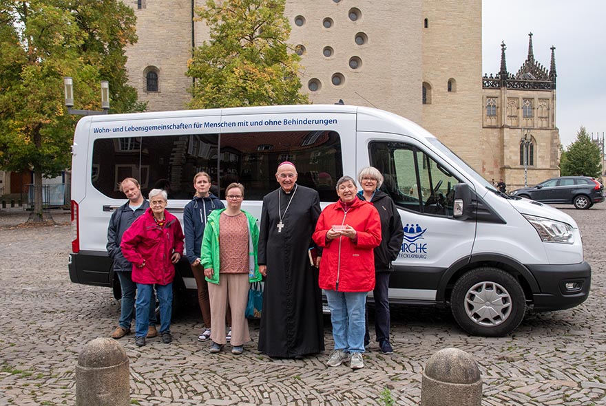 Mit Bischof Felix Genn hat sich die Gruppe von der Arche in Tecklenburg vor dem neuen Bulli aufgestellt.