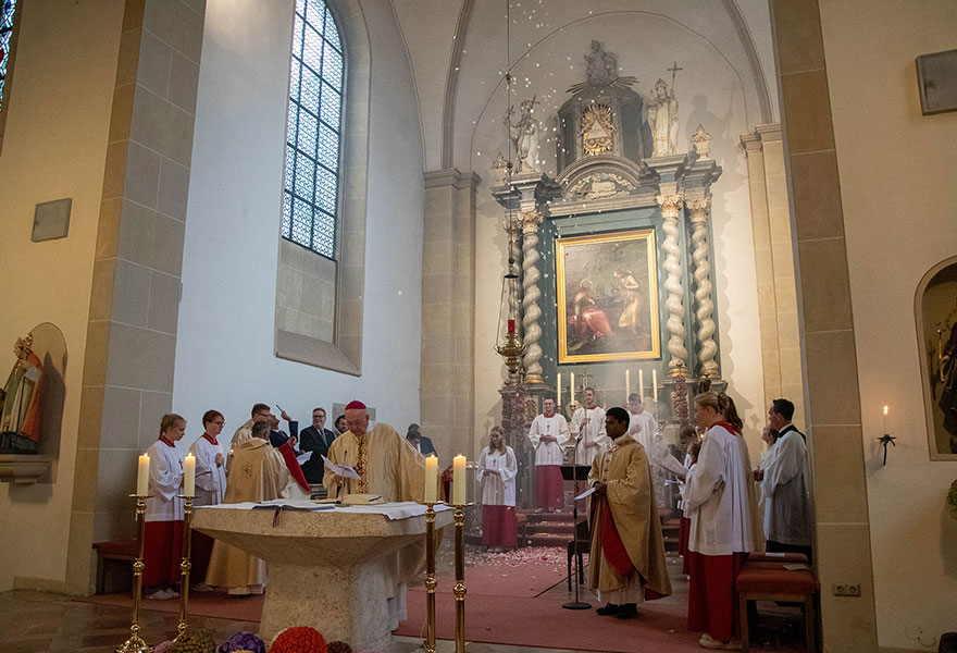 Am Altar stehen die Geistlichen und die Messdiener. 