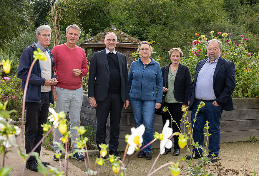 Eine Gruppe steht im Garten des Naturschutzzentrums..