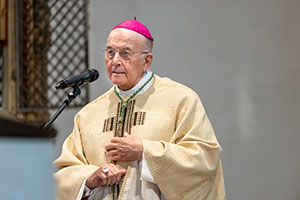 Der Bischof steht am Mikrophon und predigt. Der Bischof steht am Mikrophon und predigt.