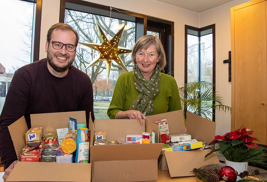 David Laudano und Anne Thier stehen hinter Kartons, die mit Lebensmitteln bepackt sind.