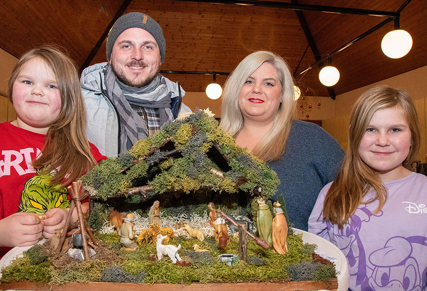 Um eine Krippe steht die Familie. Um eine Krippe steht die Familie.