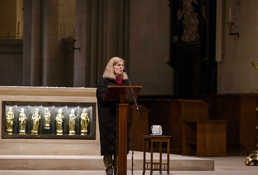 Eine Frau steht im Dom vor dem Altar an einem Pult und spricht.