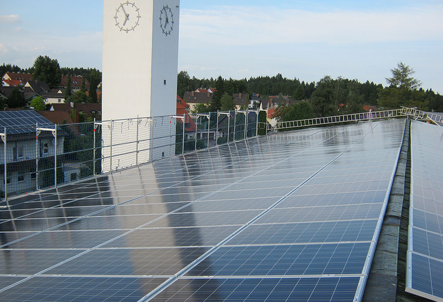 Auf dem Dach einer Kirche sind Solarmodule befestigt. 