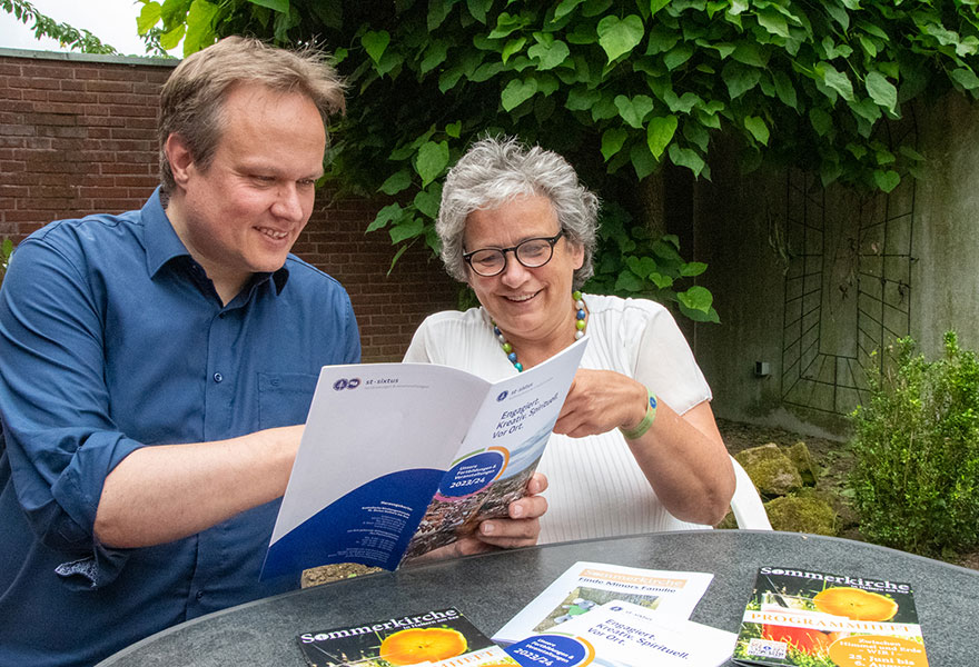 Michael Ostholthoff und Cäcilia Scholten sitzen nebeneinander und schauen in das Programm.