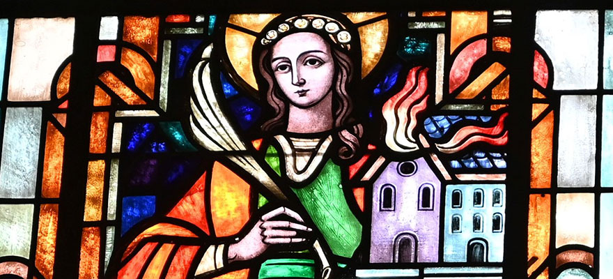 Kirchenfenster - Die bunte Bleiverglasung zeigt die heilige Agatha und das brennende Haus.