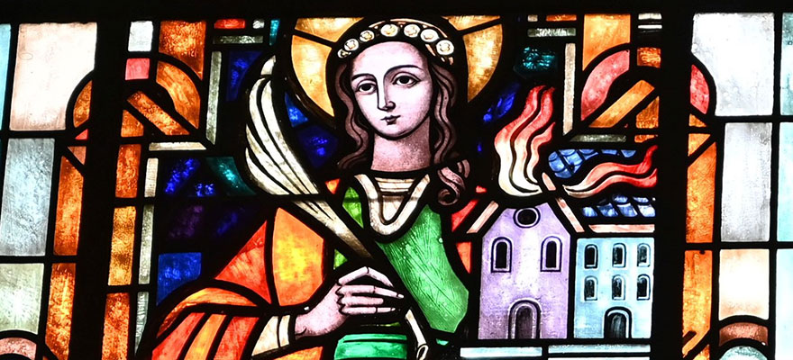 Kirchenfenster - Die bunte Bleiverglasung zeigt die heilige Agatha und das brennende Haus. Kirchenfenster - Die bunte Bleiverglasung zeigt die heilige Agatha und das brennende Haus.