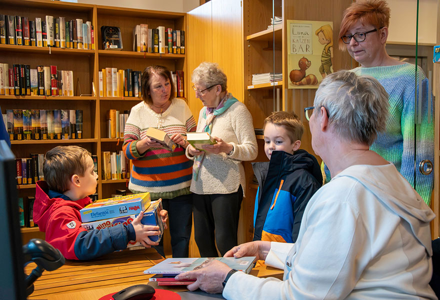 Zwei Kinder leihen sich Spiele und Bücher an der Ausleihe aus.