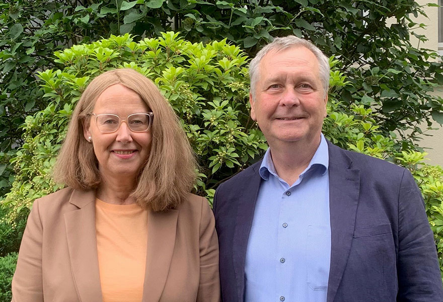 Christa Bischoff und Ulrich Knudsen stehen nebeneinander und lächeln in die Kamera..