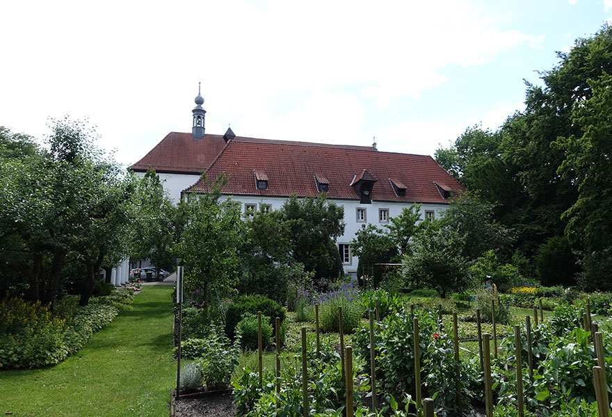 Blick durch den grünen Garten auf das Kloster der Kapuziner in Werne.