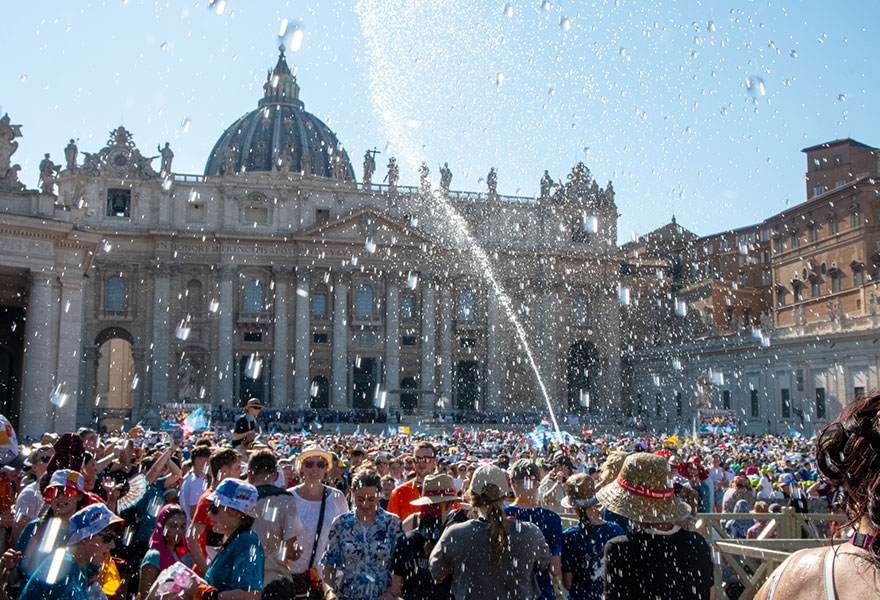 Blick auf den Petersplatz, wo Feuerwehrmänner mit Wasserfontänen Abkühlung schaffen.