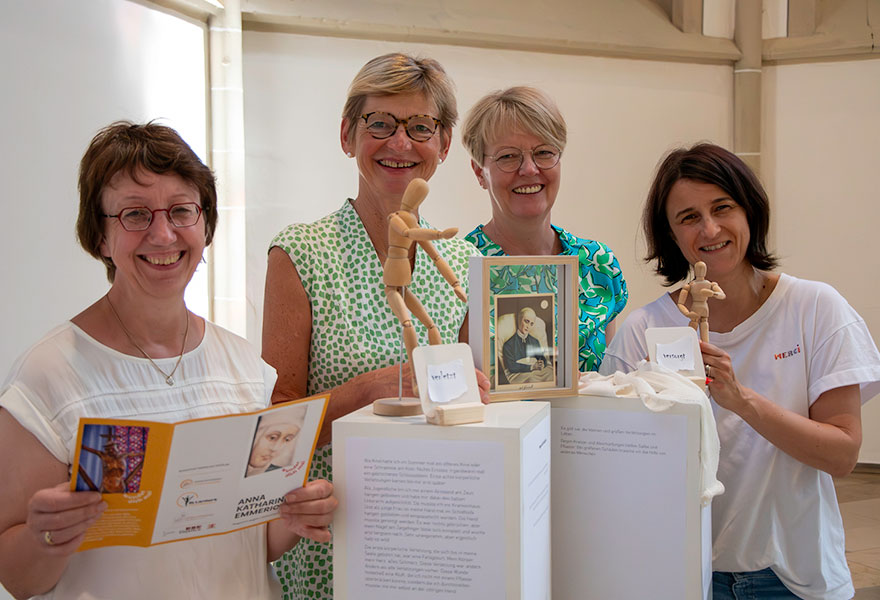 Vier Frauen stehen nebeneinander und lachen in die Kamera.
