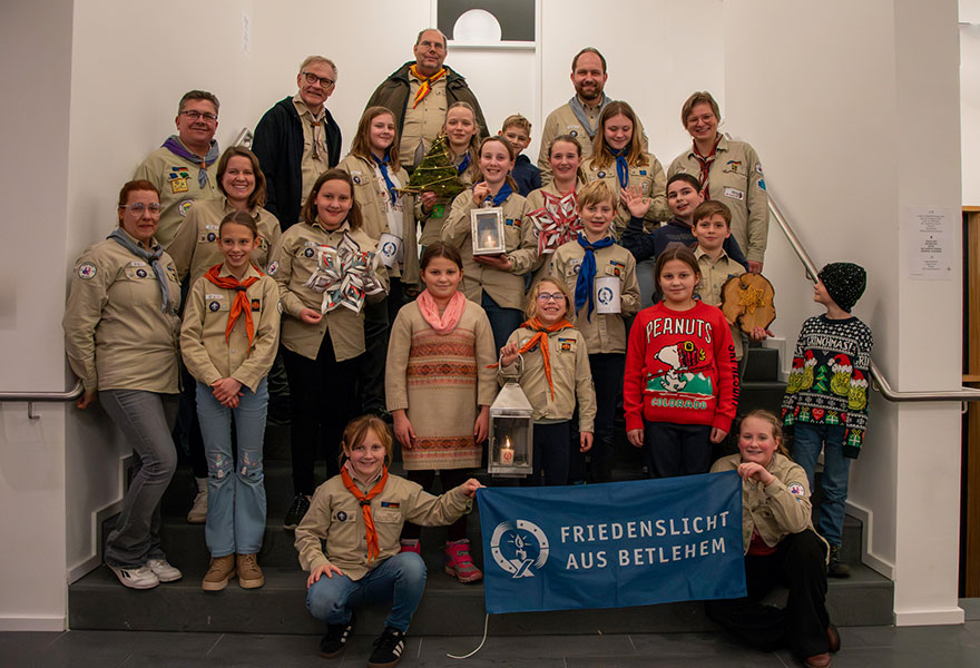 Viele Kinder und Jugendliche haben sich in der Kluft der Pfadfinder auf einer Treppe zum Gruppenbild aufgestellt.