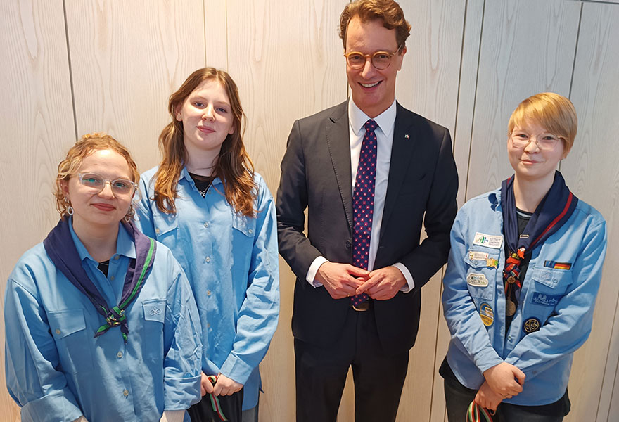 Die Pfadfinderinnen haben den Ministerpräsidenten in ihre Mitte genommen.