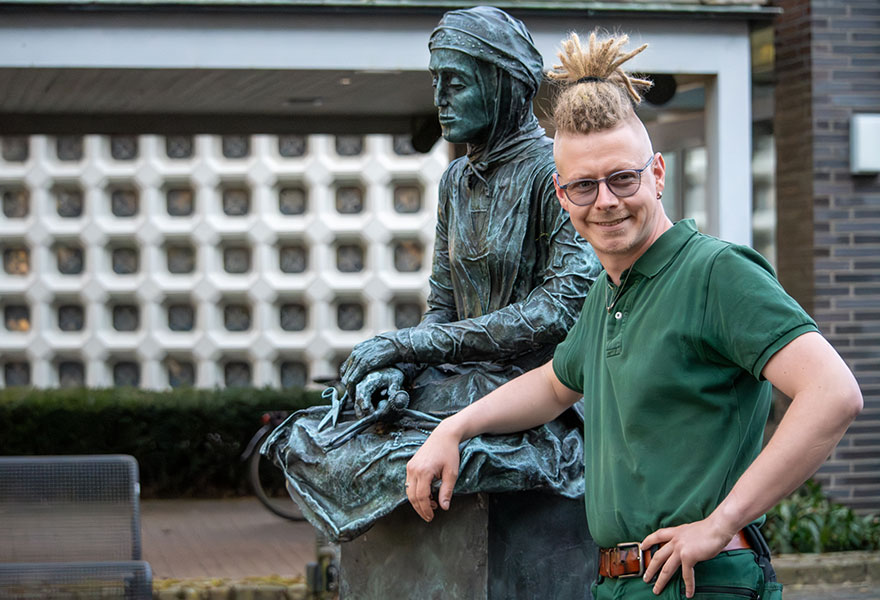 Manuel Höing lehnt sich an die Skulptur, die Anna Katharina Emmerick darstellt.