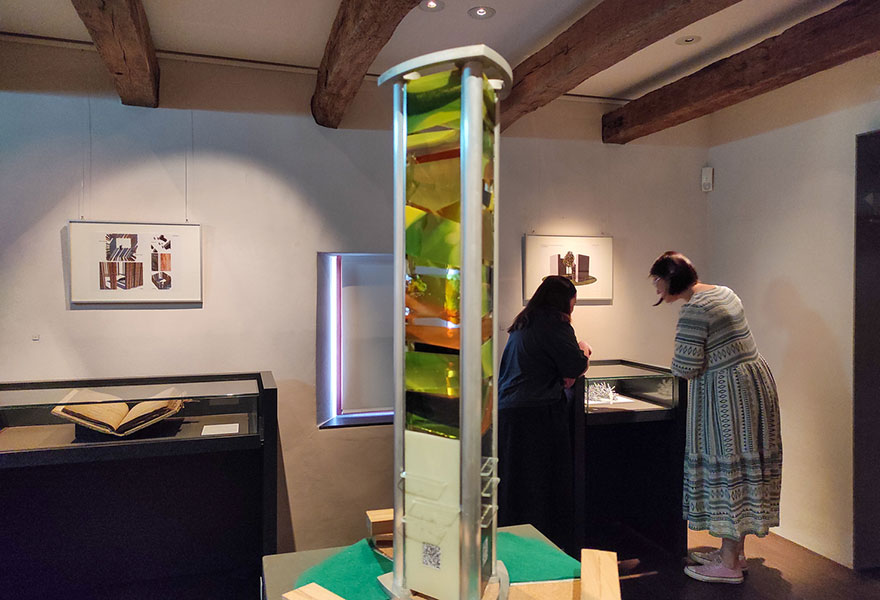 In einem Ausstellungsraum schauen sich zwei Frauen ein Exponat an.