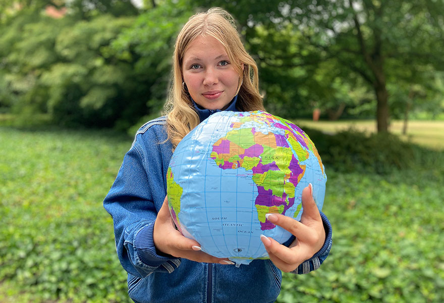 Anna Pütz zeigt auf einer aufblasbaren Weltkugel auf Afrika.