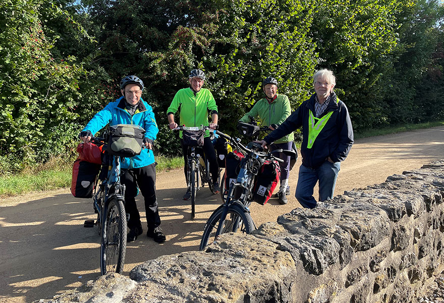 Vier Männer stehen mit ihren bepackten Fahrrädern im Halbkreis.