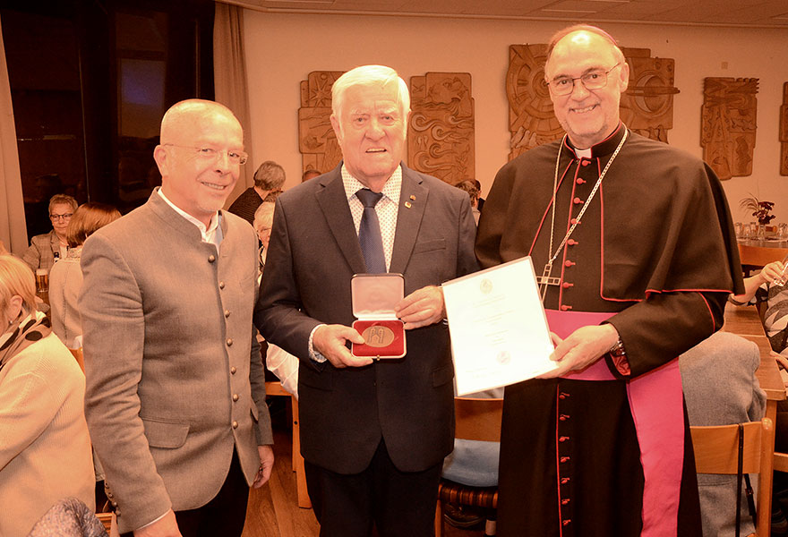Pfarrer Dietmar Heshe, Heinrich Henrichs, der die Paulusplakette zeigt, und Regionalbischof Rolf Lohmann mit einer Urkunde stehen nebeneinander und lächeln in die Kamera. Pfarrer Dietmar Heshe, Heinrich Henrichs, der die Paulusplakette zeigt, und Regionalbischof Rolf Lohmann mit einer Urkunde stehen nebeneinander und lächeln in die Kamera.