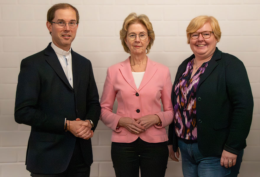 Pfarrer Dr. Oliver Rothe, Dr. Edith Holte und Pastoralreferentin Nicole Thien stehen nebeneinander und lächeln in die Kamera. Pfarrer Dr. Oliver Rothe, Dr. Edith Holte und Pastoralreferentin Nicole Thien stehen nebeneinander und lächeln in die Kamera.