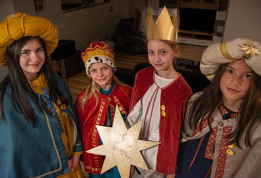 Die vier Sternsingerinnen stehen in ihren Gewändern nebeneinander.