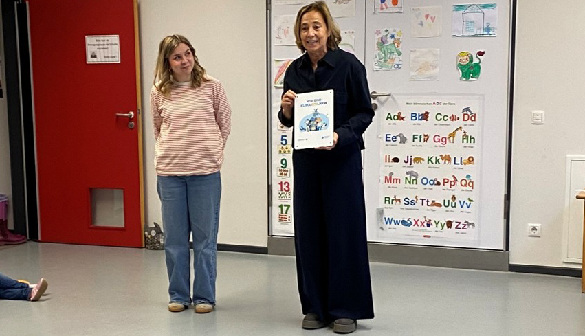 Zwei Frauen stehen nebeneinander in einem Raum, eine hält eine Urkunde in der Hand. Zwei Frauen stehen nebeneinander in einem Raum, eine hält eine Urkunde in der Hand.