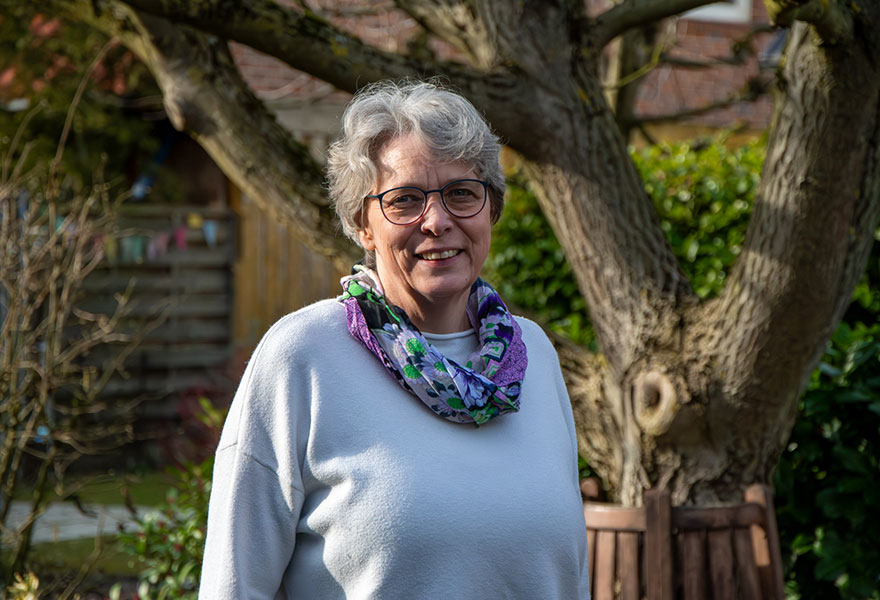 Mechthild Thiel steht im Garten und lächelt in die Kamera. Mechthild Thiel steht im Garten und lächelt in die Kamera.