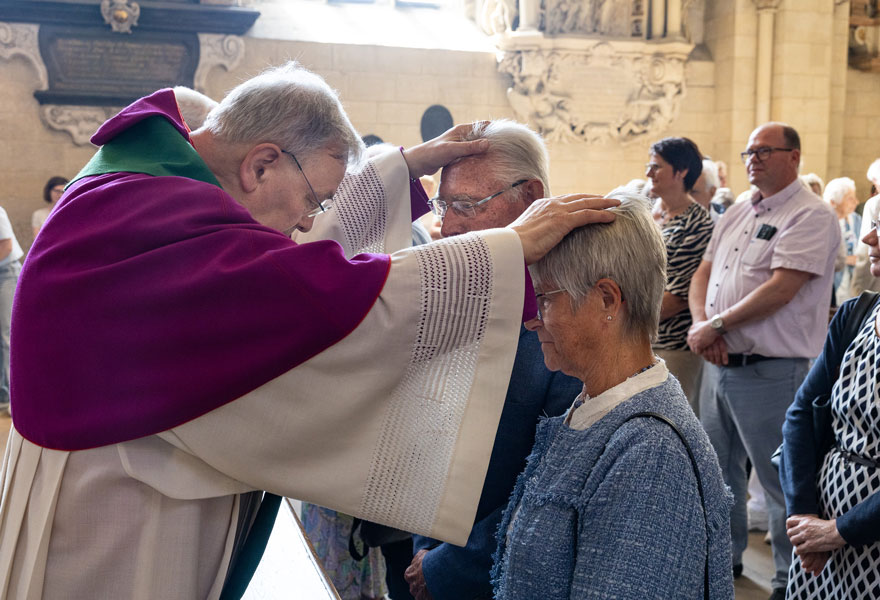 Ein Priester legt dem Jubelpaar die Hände zum Segen auf den Kopf.