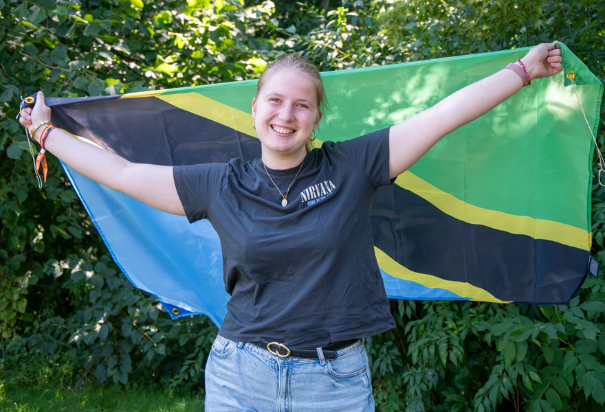 Leonie Himker hält die Fahne von Tansania hoch.