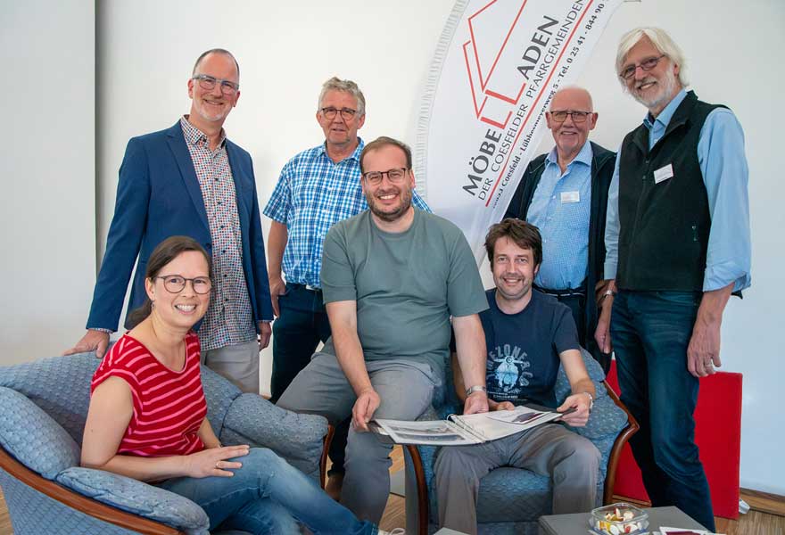 Die Verantwortlichen haben sich zum Gruppenbild hingesetzt und hingestellt.