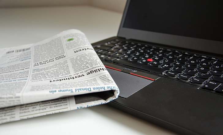 Ein Laptop und eine Zeitung.