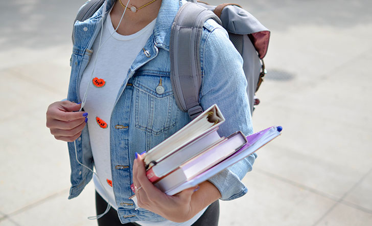 Junge Frau mit Heften und Büchern