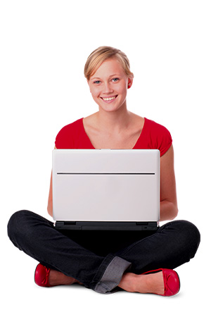 Eine junge Frau sitzt im Schneidersitz. Auf ihren beinen liegt ein aufgeklapptes Laptop.