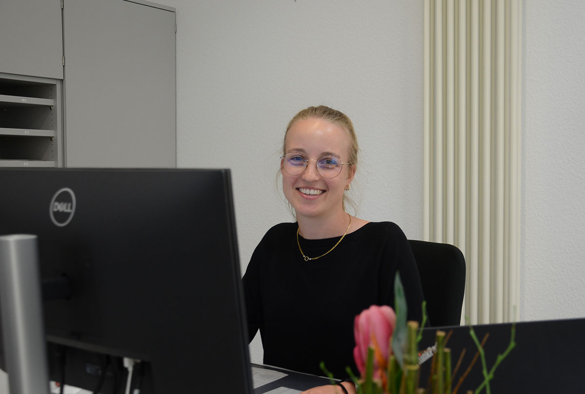 Die Auszubildende Ines Ringbeck sitzt an ihrem PC-Arbeitsplatz und lächelt in die Kamera. Die Auszubildende Ines Ringbeck sitzt an ihrem PC-Arbeitsplatz und lächelt in die Kamera.