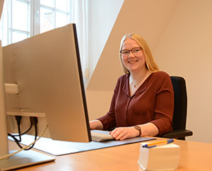 Die duale Studentin Odila Becks sitzt vor einem PC-Bildschirm an einem Schreibtisch.