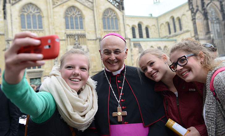 Jugendliche machen ein Selfie mit dem Bischof