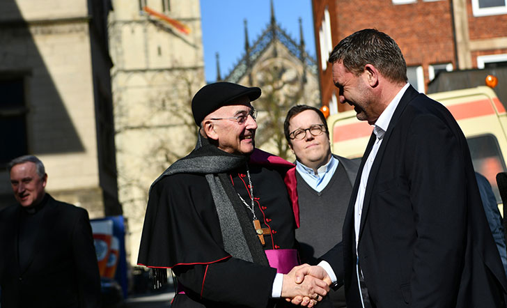 Bischof Genn begrüßt einen Gast auf seiner Geburtstagsfeier.