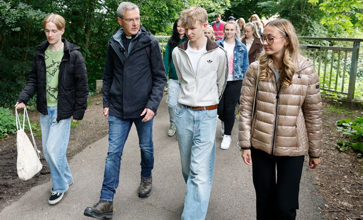 Bischof Dr. Heiner Wilmer unterhält sich unterwegs mit Schülerinnen und Schülern.