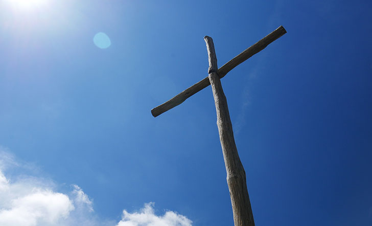 Ein Kreuz vor blauem Himmel