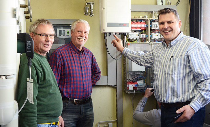 Mitglieder des Freundeskreises stehen vor der Technik der PV-Anlage.