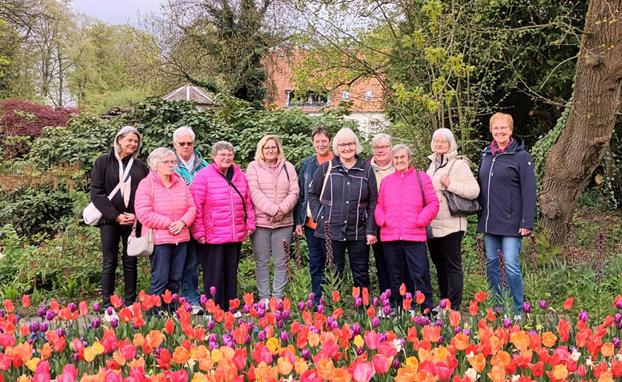 Eine Gruppe Frauen steht in einem Park hinter einem bunten Tulpenbeet. Eine Gruppe Frauen steht in einem Park hinter einem bunten Tulpenbeet.