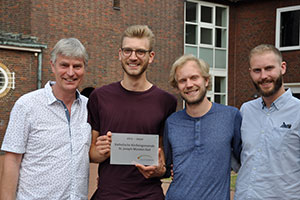 Die Schonhoffs halten stolz die "Zukunft einkaufen"-Plakette in ihren Händen.